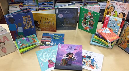 Culturally diverse books arranged on a table in a display