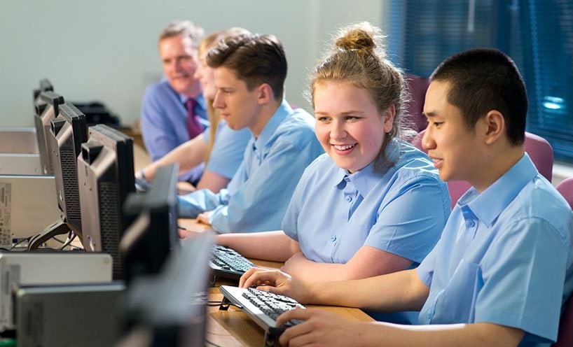 School students using computer, typing and looking at monitor.