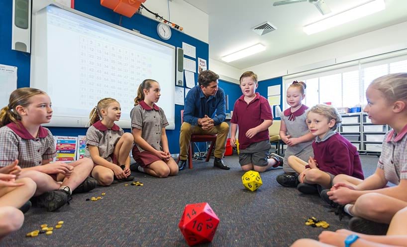 A teacher is doing an activity with some students in a classroom.