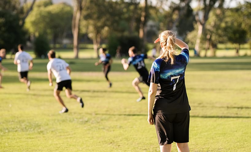 A group of people playing a game of football in a field.